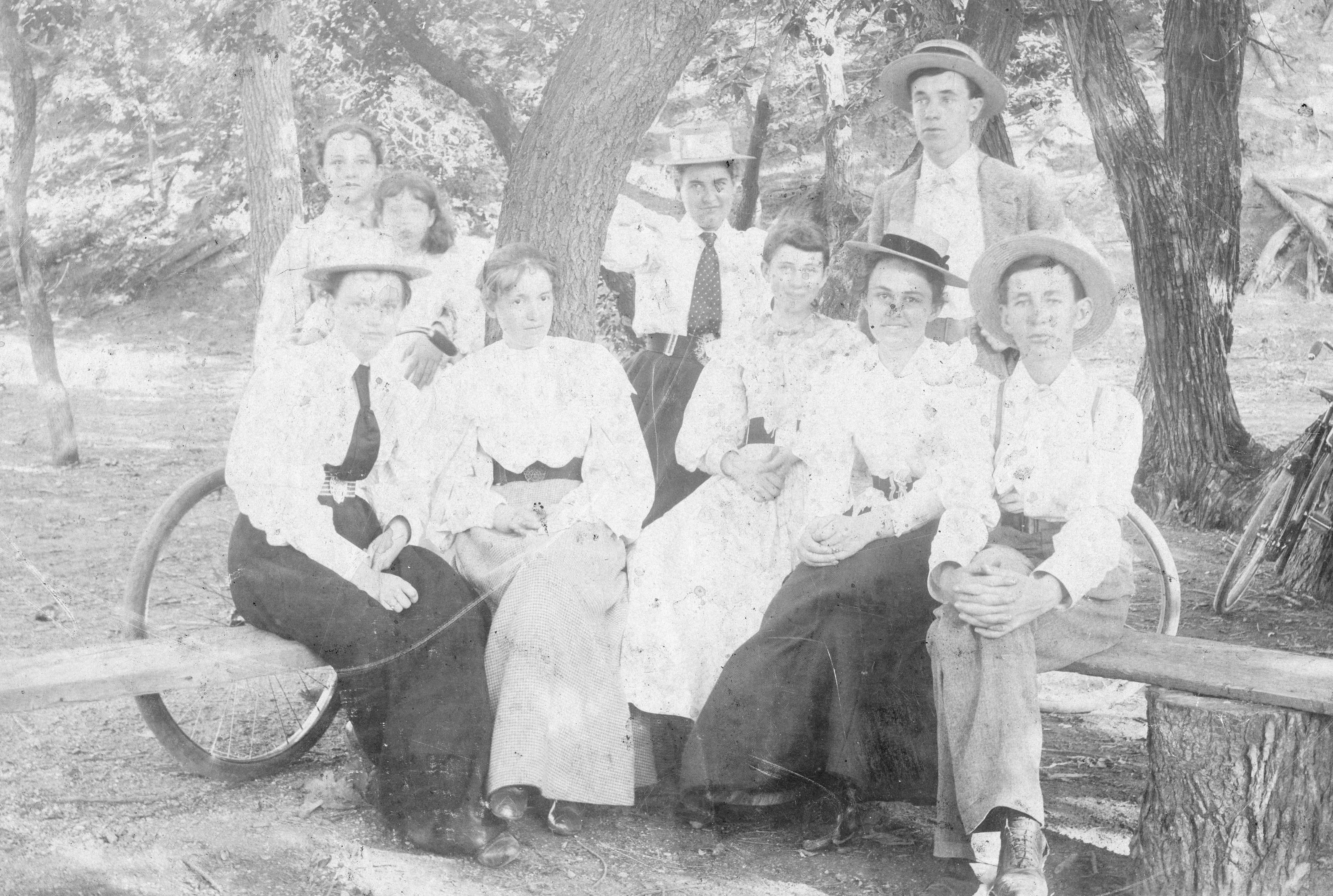 Willa Cather and friends sit with their bicycles, circa 1890