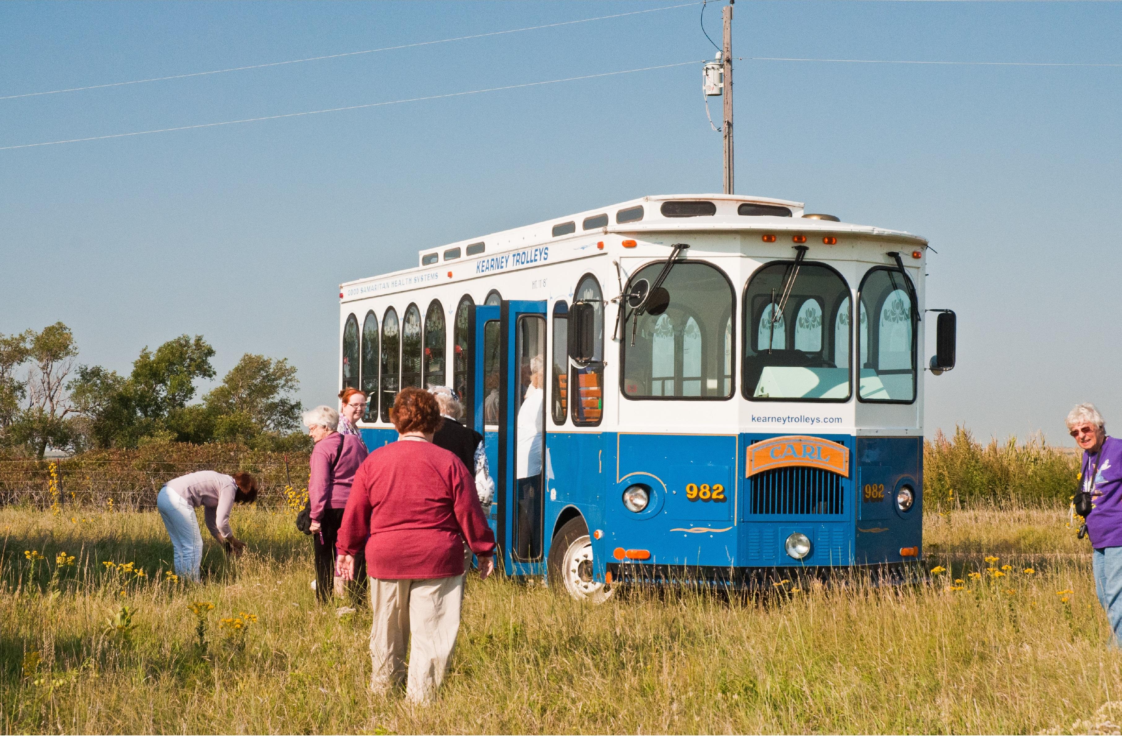Group Tours Visitors walk outside near a trolley bus.