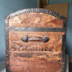 Exterior side view of the E.C. Cather trunk. Name printed below the handle.