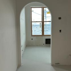 Arched doorway leading from hotel room entrance to the bedroom.