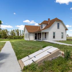 Exterior of the Pavelka Farmstead with the root cellar doors in the foreground,