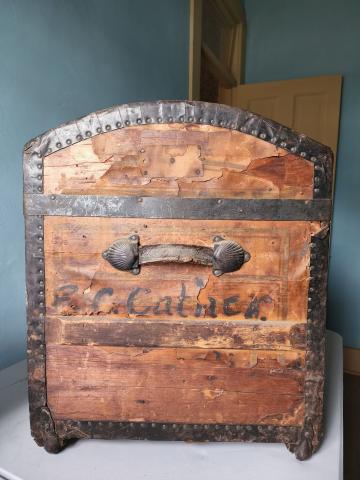 Exterior side view of the E.C. Cather trunk. Name printed below the handle.