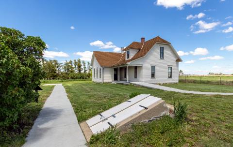 Exterior of the Pavelka Farmstead with the root cellar doors in the foreground,