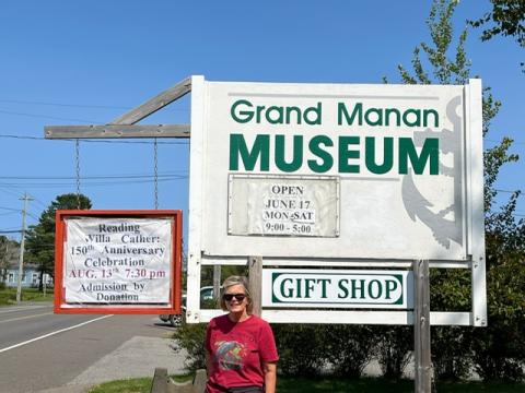 Sharon Kohout stands in front of the Grand Manan Museum sign