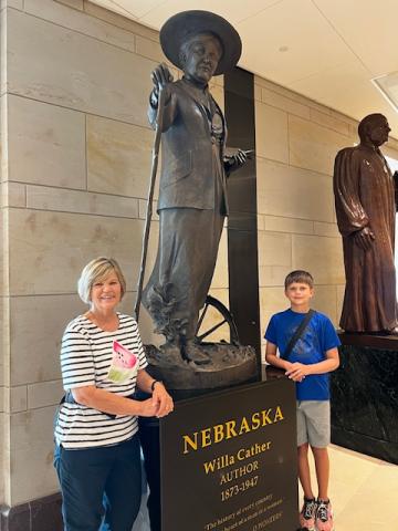 Sharon Kohout and her grandson in front of the Cather statue in the U.S. Capitol