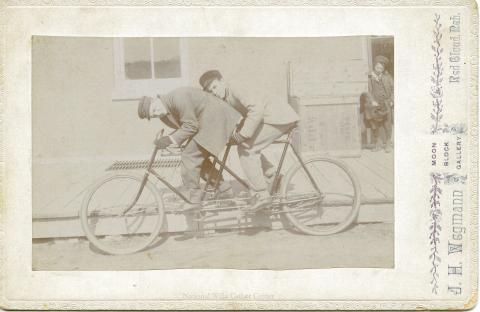 Hugh Miner and Roscoe Cather on a bicycle